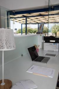 a laptop computer sitting on a desk with a lamp at Akroyiali Resort in Vasiliki