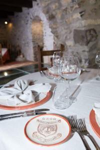 a table with plates and wine glasses on it at Hotel Ristorante Mulino Iannarelli in San Severino Lucano
