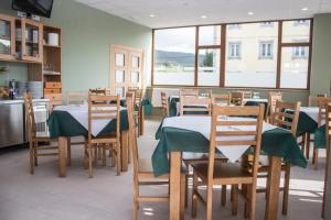 restauracja ze stołami i krzesłami z zielonymi obrusami w obiekcie O Vendaval Hostal Restaurante w mieście Barreiros