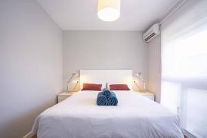 ein Schlafzimmer mit einem großen weißen Bett mit zwei Kissen in der Unterkunft Malagueta Cool Beach Apartment in Málaga