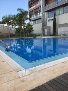 une piscine bleue en face d'un bâtiment dans l'établissement Loft with terrace 24m2, swimming pool and garage, à Chirivella