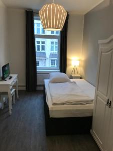 Schlafzimmer mit einem Bett, einem Schreibtisch und einem Fenster in der Unterkunft Hotel Fame am Hauptbahnhof in Hamburg