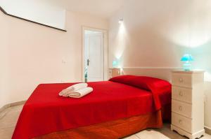 um quarto com uma cama vermelha com duas toalhas em Appartamento Chicca em Sperlonga