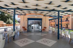 a restaurant with tables and chairs on a balcony at Akroyiali Resort in Vasiliki