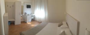 a white room with a bed and a sink at Hotel La Pace in Pontedera