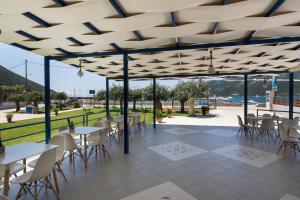 a restaurant with tables and chairs under a pavilion at Akroyiali Resort in Vasiliki