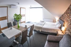 um quarto com uma cama, uma mesa e cadeiras em Willa Plaza em Łeba