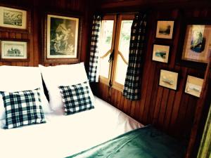 ein Schlafzimmer mit einem Bett mit Kissen und einem Fenster in der Unterkunft Gîte et Roulotte dans les Vosges in Remiremont