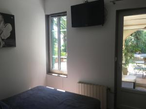 a bedroom with a bed and a window and a television at La Mandarinette in La Seyne-sur-Mer
