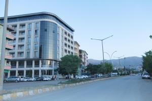 a large building on a city street with cars parked at Mus Grand Hotel in Muş