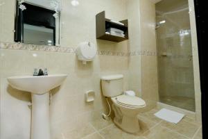 a bathroom with a toilet and a sink and a shower at Hotel Arawak Upar in Valledupar +37 photos