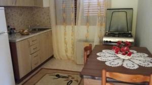 una piccola cucina con tavolo e specchio di Guesthouse Fatos Biti a Divjakë