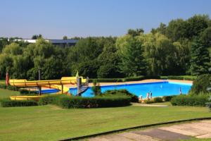 a large pool with a slide in a park at Hotel Koldum in Litvínov