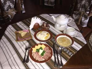 a table with plates of food and a teapot at Туристично розважальний комплекс "Стіжок" in Berehomet