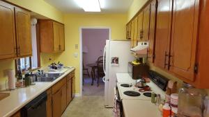 a kitchen with wooden cabinets and a white refrigerator at The Dock House in Calabash