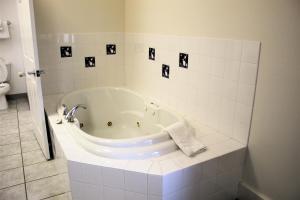 a bath tub in a bathroom with black and white tiles at Puffin Inn in Anchorage
