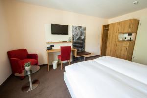 a hotel room with a bed and a desk and chairs at Ochsen Lenzburg in Lenzburg