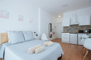Un dormitorio blanco con una cama grande con toallas. en Charming Terrace - Sunny Chill Out Terrace, en Sevilla