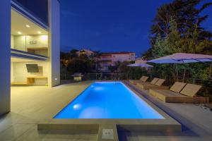 a swimming pool in front of a house at night at Villa Celeia in Krk