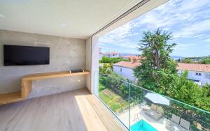 a room with a balcony with a large window at Villa Celeia in Krk
