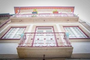 a building with a balcony with two plants on it at Casa da Vila in Ponte de Lima