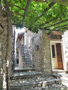un edificio de piedra con escalera y puerta en Casa Serendipity, en Vercana