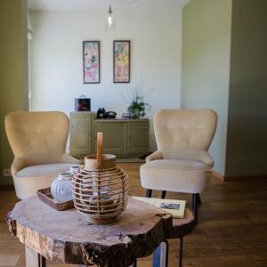 a living room with two chairs and a table at La croisée des champs, gîte entre Durbuy et La Roche en Ardenne in Érezée