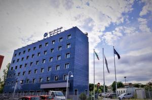 niebieski budynek z samochodami zaparkowanymi przed nim w obiekcie Best Western Palace Inn Hotel w mieście Ferrara