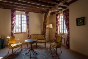 uma sala de estar com uma mesa, cadeiras e janelas em Le Patio & Spa em Saumur