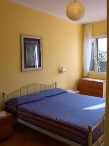 sypialnia z łóżkiem z niebieską kołdrą w obiekcie Casa Gialla w mieście Imperia