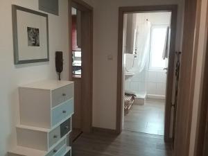 Zimmer mit weißer Kommode und Bad in der Unterkunft Ferienwohnung S-Bahn Nähe in Schwaikheim + 10 Fotos