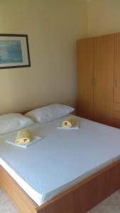 a large white bed with two towels on it at Guesthouse BILI in Karlobag