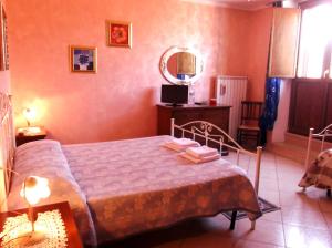 1 dormitorio con cama, mesa y espejo en Dolcedorme Bed And Breakfast, en Terranova di Pollino