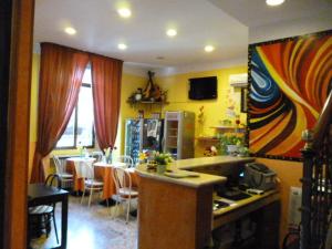 a kitchen and dining room with a table and a kitchen with yellow walls at Hotel San Giovanni in Milan