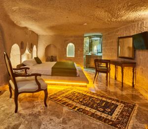 a bedroom with a bed and a desk in a room at Wings Cappadocia in Uchisar