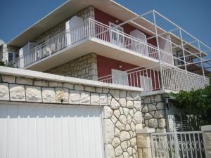un bâtiment avec une porte de garage blanche et une clôture dans l'établissement House Tonka Apartment, à Hvar