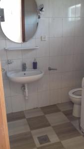 ein Badezimmer mit einem Waschbecken, einem WC und einem Spiegel in der Unterkunft Tajči in Ugljan