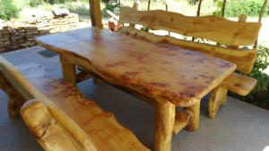 einen Holztisch und eine Bank mit einem Holztisch und Stühlen in der Unterkunft Tajči in Ugljan