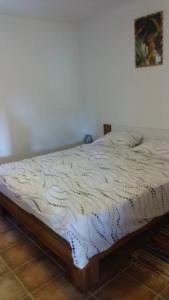 Bett in einem Schlafzimmer mit weißer Decke in der Unterkunft Tajči in Ugljan