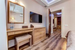 a bedroom with a desk and a tv on a wall at Premium Hotel in Saint Petersburg