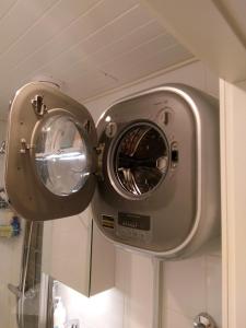 a washer and dryer in a bathroom at Parantolankatu modern one room apartment in Hyvinkää