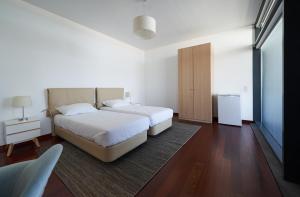 a bedroom with two beds and a rug at Marina Rooms in Calheta +31 photos