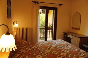 a bedroom with a bed with a lamp and a window at albergo ristorante le fontane in Gargnano
