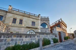an old stone building with a balcony on top at Wings Cappadocia in Uçhisar