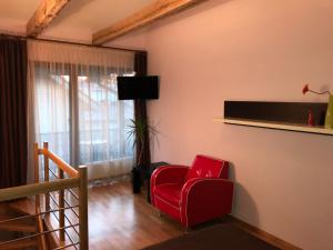 a living room with a red chair and a television at Vila Saulė in Palanga