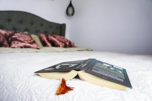 een boek op een bed bij Mono Ray Apartments in Druskininkai