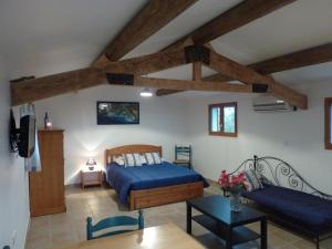 a bedroom with a blue bed and a couch at Les Mazets du Paty in Albaron