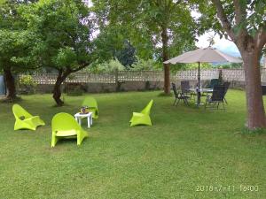eine Gruppe Stühle und ein Regenschirm auf einem Hof in der Unterkunft Estudio y Loft Durango in Guyuria