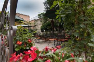 een patio met tafels, stoelen en bloemen bij Hotel Villa Delle Rose in Rome