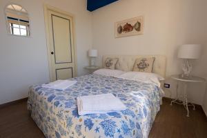 1 dormitorio con 1 cama con manta azul y blanca en Taormina Isola Bella Apartment - Taormina Holidays en Taormina